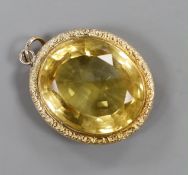A yellow metal mounted oval cut citrine pendant, overall 49mm, gross weight 23.3 grams.
