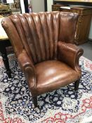 A Ralph Lauren brown leather tub framed library wing armchair on square tapered legs width 96cms,