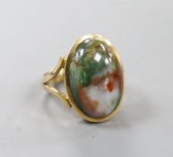 A yellow metal and cabochon polychrome agate? set oval ring, with engraved inscription to the shank,