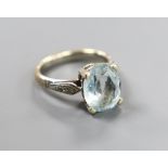 A modern yellow and white metal, oval cut aquamarine set dress ring, with diamond chip set