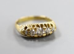 An Edwardian 18ct gold and graduated five stone diamond set half hoop ring, size P, gross weight 4.9