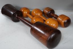 A large treen dumbbell / press together with three wooden American dumbbells by A.G. Spaulding &