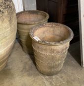A pair (in 2 sizes) of circular earthenware garden planters, larger height 51cm