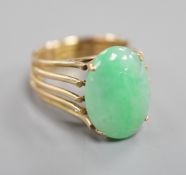 A yellow metal and cabochon jade set oval dress ring, size P/Q, gross weight 8.4 grams.