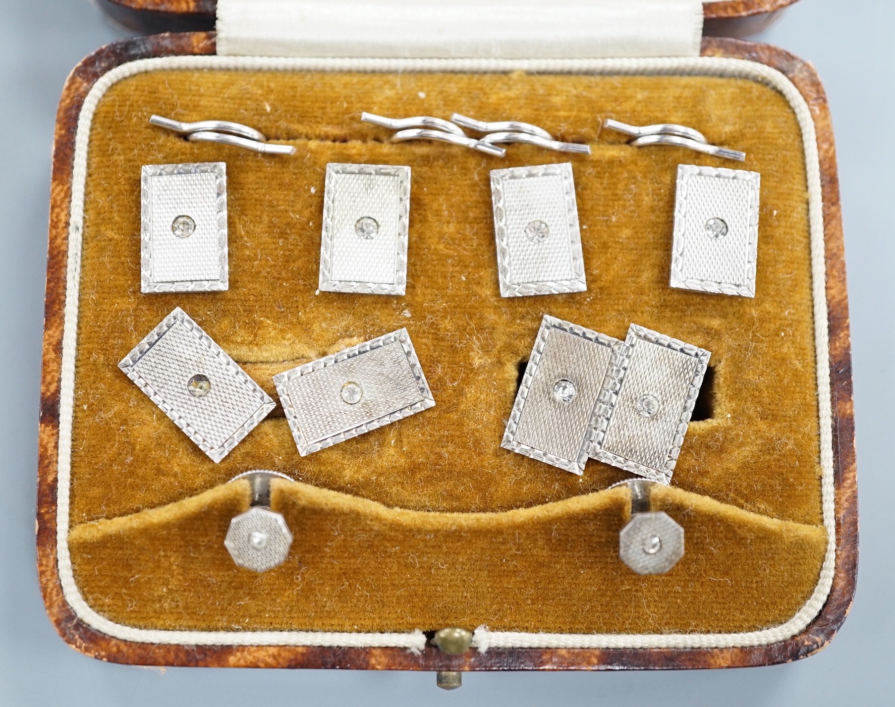 A cased 1930's engine turned silver eight piece dress stud set, by Henry Griffiths & Sons Ltd.