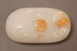 A Chinese white and russet jade pebble
