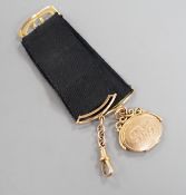 A Victorian yellow metal oval locket fob, hung from a yellow metal mounted black suspension sash,