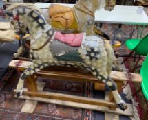 An early 20th century Ayres type carved wood and dappled rocking horse on safety frame, length