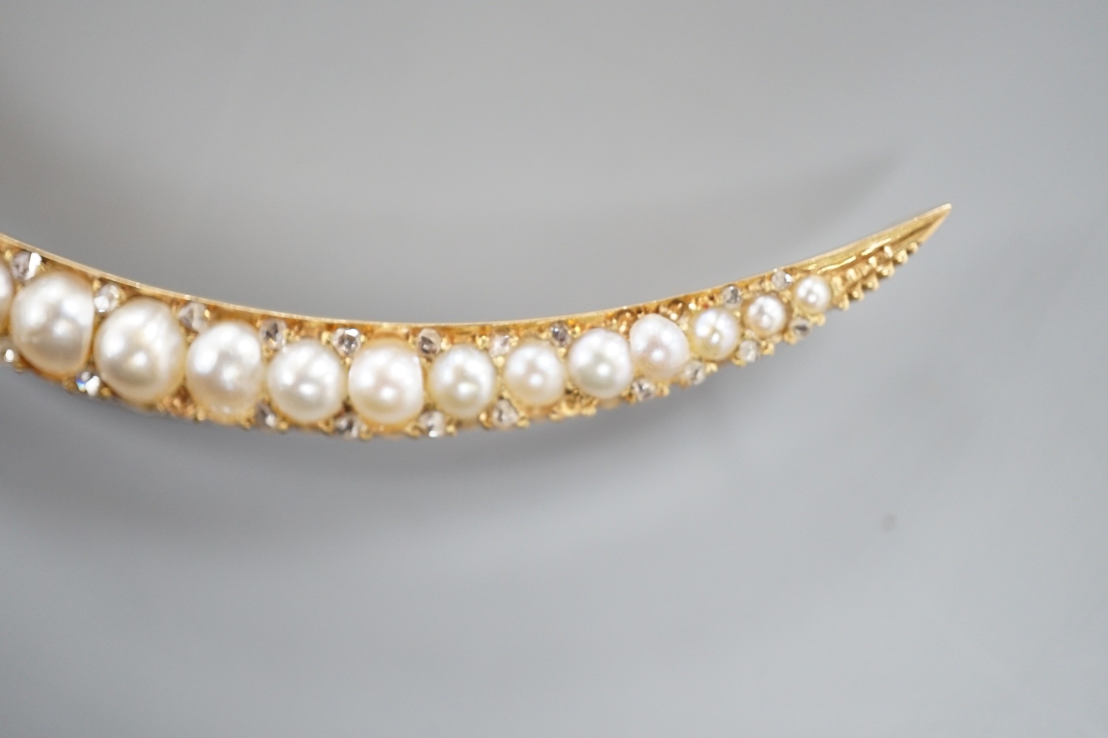An early 20th century yellow metal and graduated split pearl set crescent brooch, with diamond - Image 4 of 5