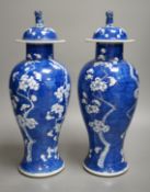 A pair of 19th century Chinese blue and white prunus vases, one a.f, 37cm