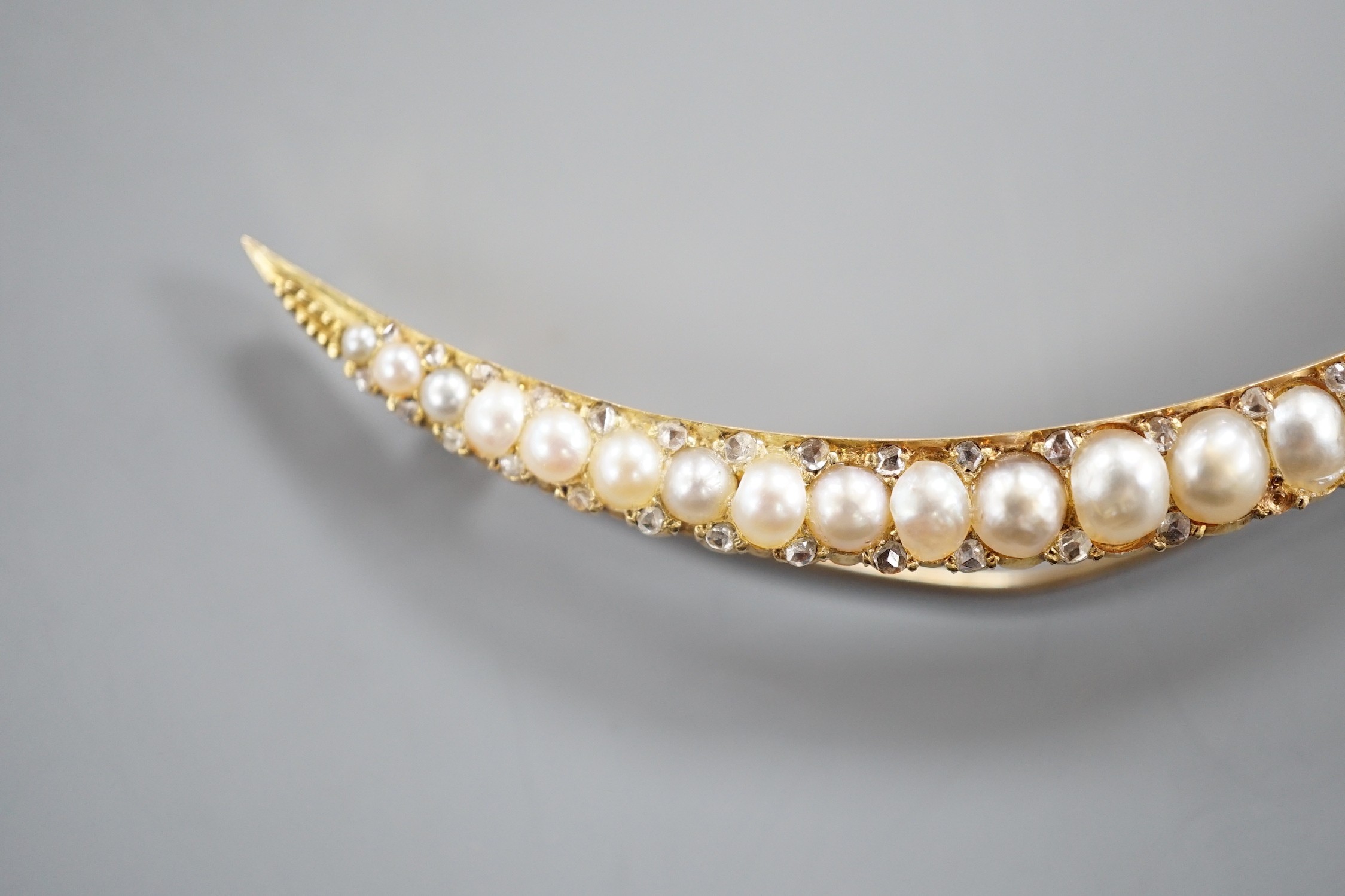 An early 20th century yellow metal and graduated split pearl set crescent brooch, with diamond - Image 2 of 5