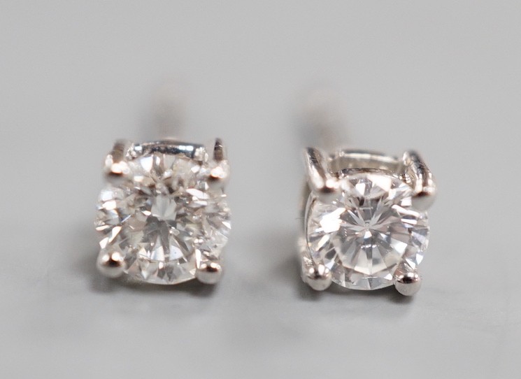 A modern pair of 9ct white gold and solitaire diamond set ear studs, gross 0.8 grams, total