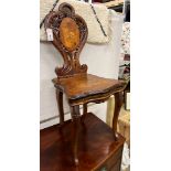 A 19th century Black Forest carved walnut musical chair decorated with panels of deer, width 45cm,