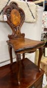 A 19th century Black Forest carved walnut musical chair decorated with panels of deer, width 45cm,