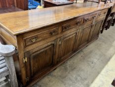 A large reproduction 18th century style oak sideboard, with four drawers and two pairs of hinged
