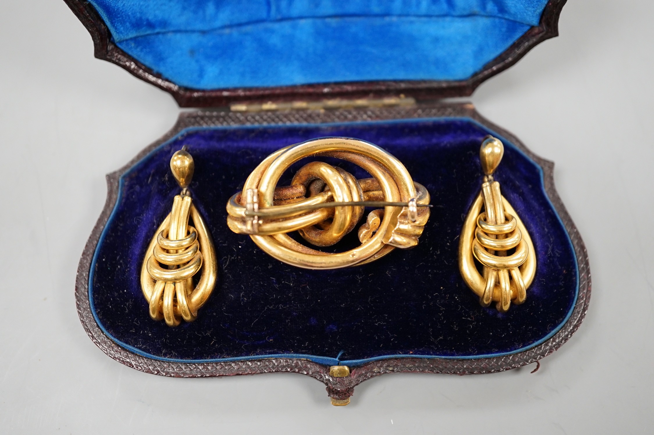 A cased Victorian yellow metal demi parure, comprising a brooch and pair of earrings of entwined - Image 2 of 2