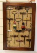 A collection of vintage corkscrews, some novelty, in glazed mahogany vase with key