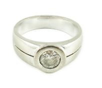 A modern 18k white gold and collet set solitaire diamond ring, with pierced shoulders, the stone
