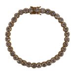 A modern 18k gold and round brilliant cut diamond set line bracelet, set with thirty five stones,