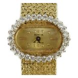 A lady's modern Swiss 14k gold and diamond set manual wind oval wrist watch, on integral 14k gold