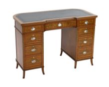 An Edwardian painted satinwood kneehole desk, with concave front and bowed back and decorated in the