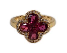 A modern 18k gold four stone pear shaped pink tourmaline set dress ring with diamond chip set
