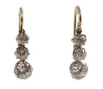 A pair of early to mid 20th century gold, platinum and graduated three stone diamond set drop