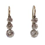 A pair of early to mid 20th century gold, platinum and graduated three stone diamond set drop