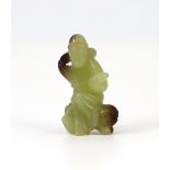 A Chinese yellow and brown jade figure of a man seated on a creature, 19th century, the greenish