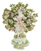A Bow porcelain bocage figure of a lady, c.1765, the lady standing before bocage on a flower