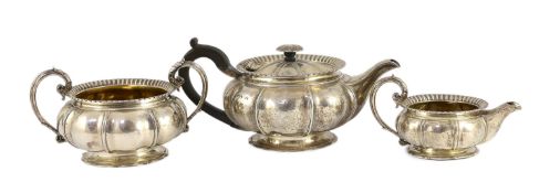 A George IV silver three piece tea set by Benjamin Smith III, of squat melon form, with ornate
