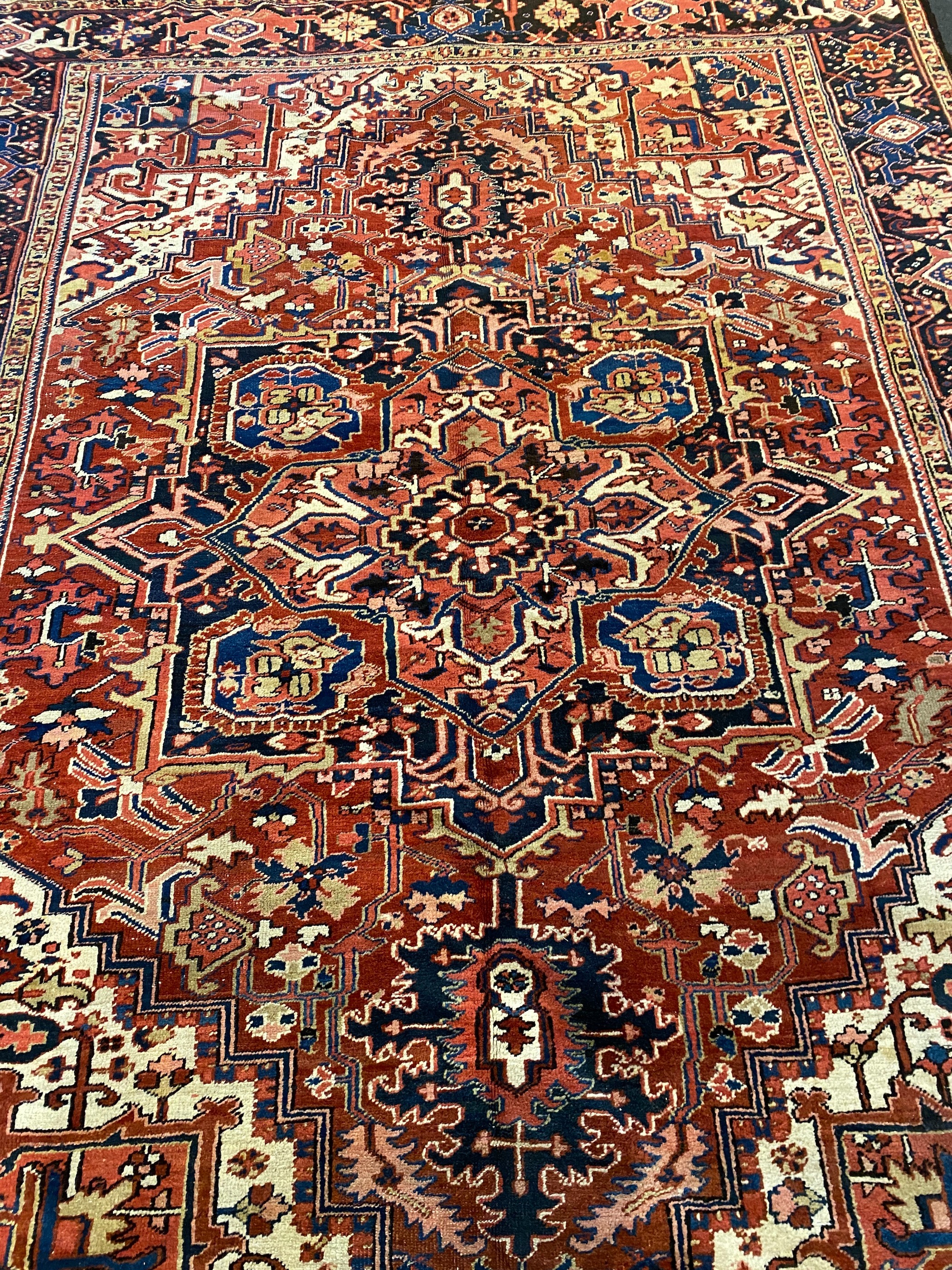 An Heriz red ground carpet, with a lobed central medallion within a floral field and wide conforming - Image 4 of 7