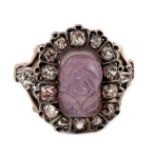 A 19th century gold, carved amethyst and diamond cluster set dress ring, the stone carved with a