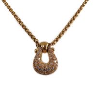 A modern French 18ct gold and pave set diamond 'U' shaped pendant, on a French 18ct gold chain,