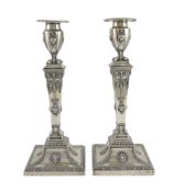 An ornate pair of late Victorian silver candlesticks by Mappin Bros., with waisted square columns
