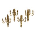 A set of four early 20th century Louis XVI style ormolu three branch wall lights, with acanthus,