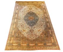 An early 20th century Tabriz ivory ground carpet, with central lobed medallion and dense floral