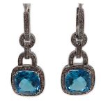 A modern pair of 14kt white gold, blue topaz and diamond chip set drop earrings, each topaz weighing