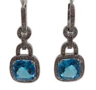 A modern pair of 14kt white gold, blue topaz and diamond chip set drop earrings, each topaz weighing
