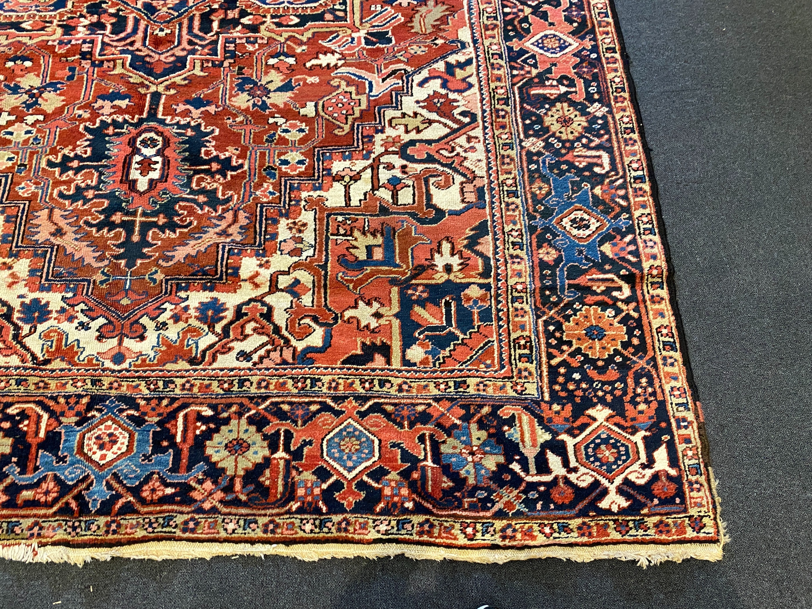 An Heriz red ground carpet, with a lobed central medallion within a floral field and wide conforming - Image 2 of 7