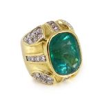 A large gold and single stone oval cut emerald set dress ring, with round and princess cut diamond
