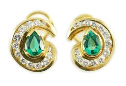 A modern pair of gold (tests as 18ct), emerald and diamond set scrolling cluster earrings, total