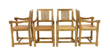 A set of four Robert Thompson 'Mouseman' oak armchairs With carved latticework splats plain arms and