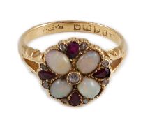 An Edwardian 18ct gold, ruby, white opal and diamond set circular cluster dress ring, with split