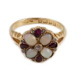 An Edwardian 18ct gold, ruby, white opal and diamond set circular cluster dress ring, with split