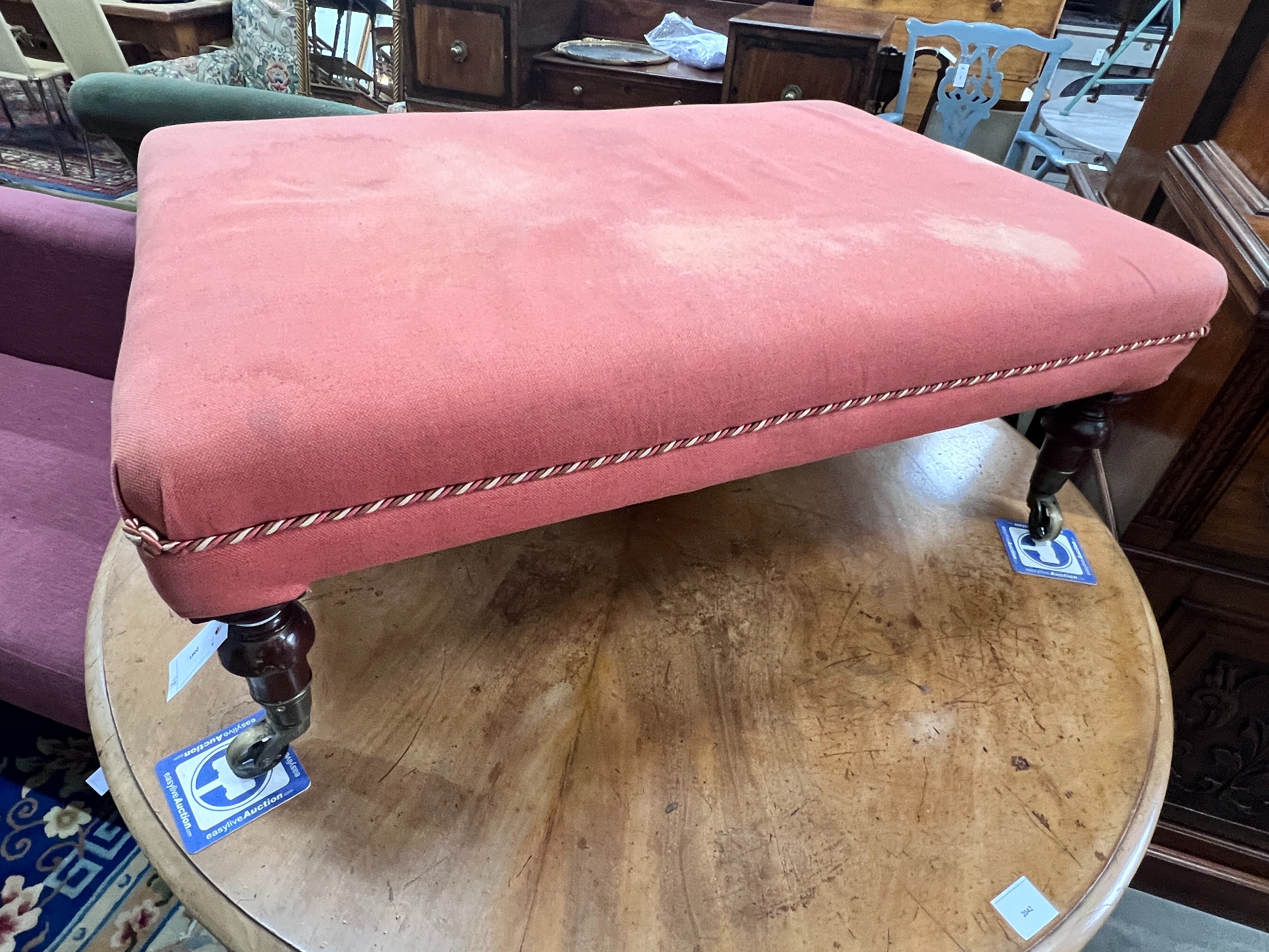 A Victorian rectangular stool on turned mahogany legs with spoked castors, length 93cm, width