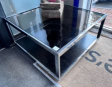 A pair of chrome and smoked glass Merrow associates style two tier occasional tables,