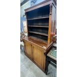 A late Victorian oak bookcase with twin panelled cupboard base, length 122cm, depth 51cm, height