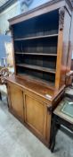 A late Victorian oak bookcase with twin panelled cupboard base, length 122cm, depth 51cm, height