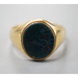 A yellow metal (stamped 18) and bloodstone set oval ring, size S/T, gross 7.9 grams.